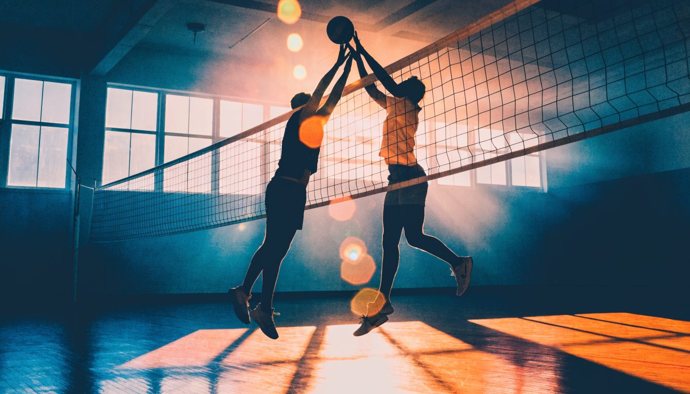 Volleyball players contesting a block at the net