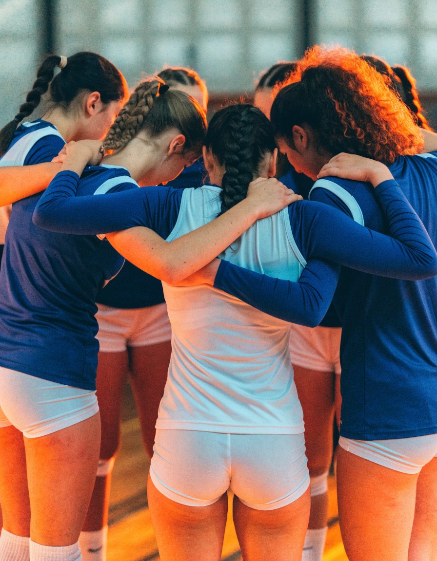 A club team huddled together, shot from behind